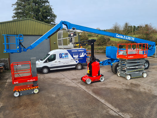 Set of aerial lifts and a van with branding in an outdoor setting